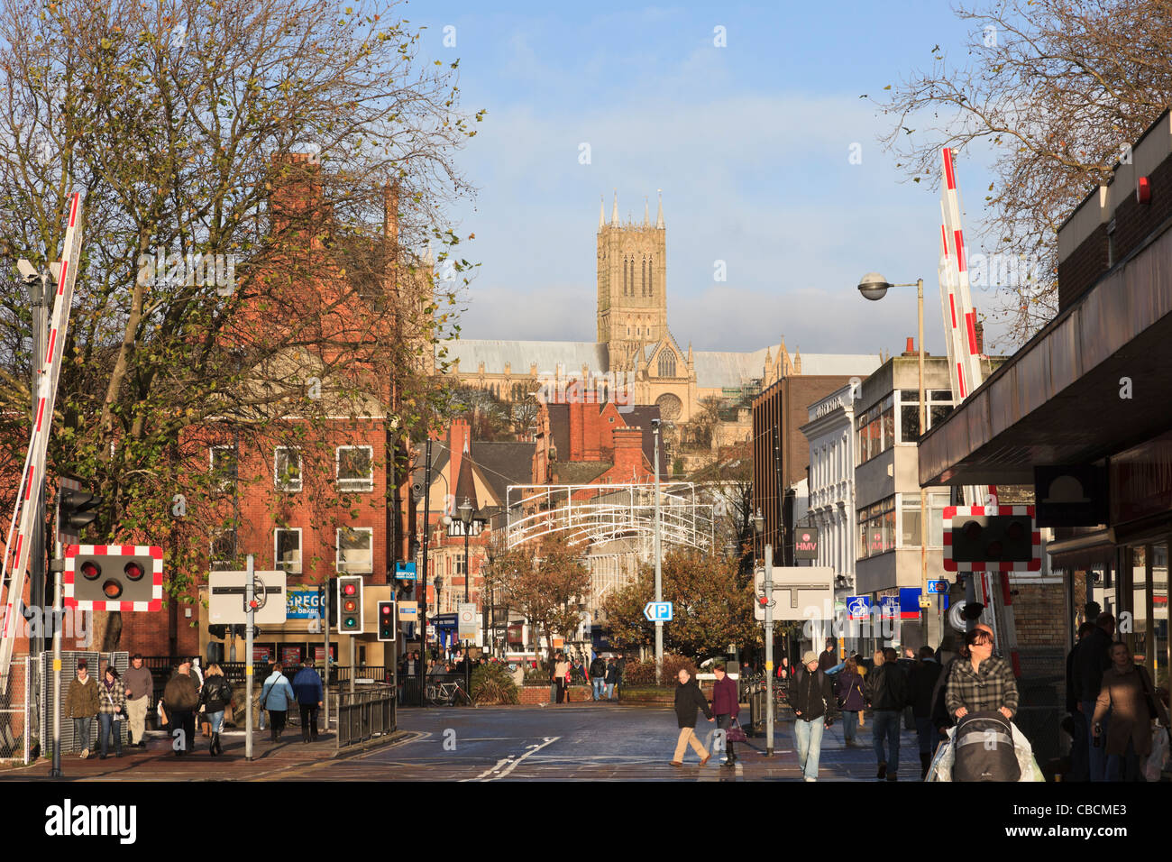 Street scene with shoppers shopping at Christmas and cathedral dominating skyline. High Street Lincoln Lincolnshire England UK Stock Photo