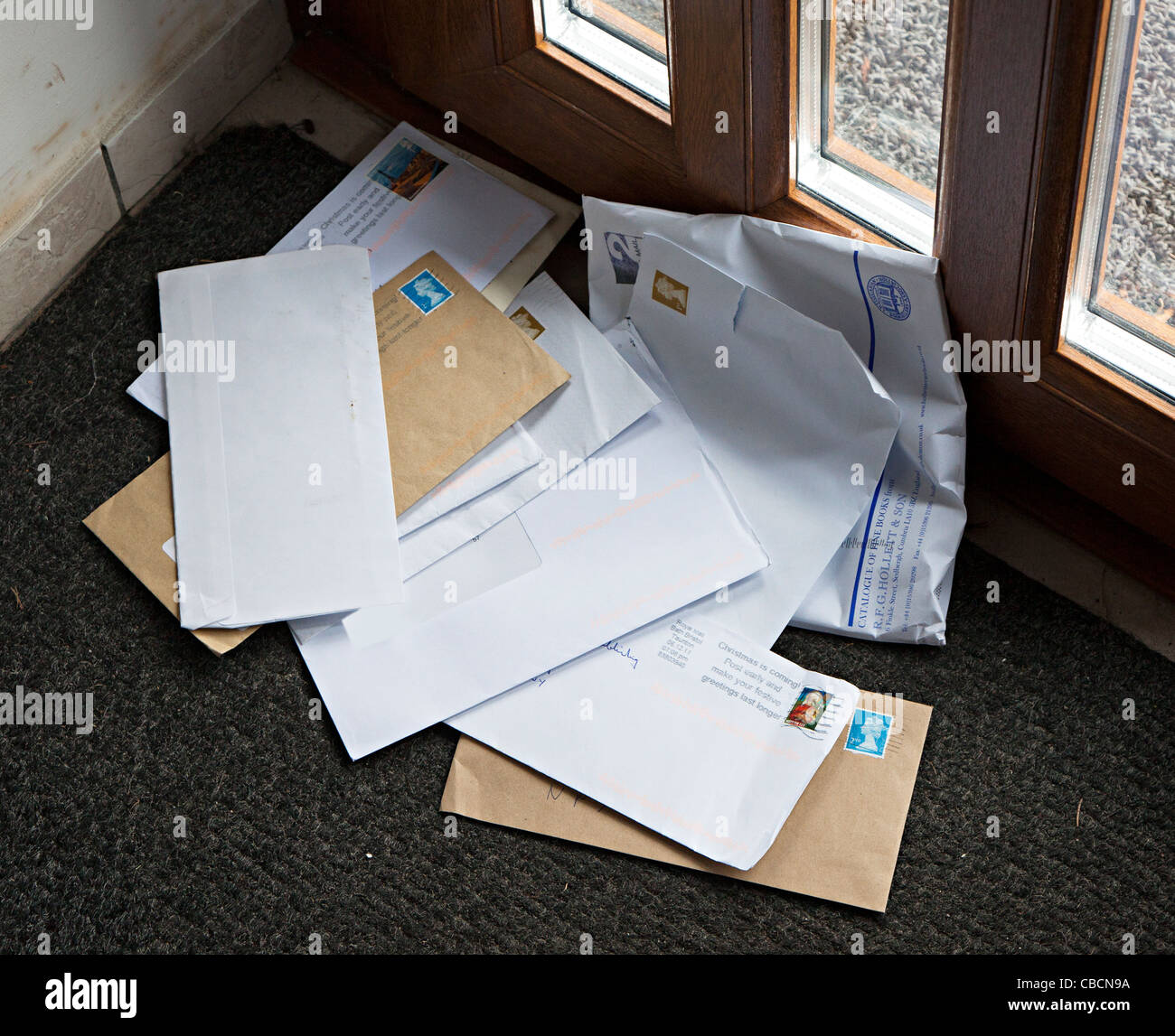 Letters delivered to house in heap on doormat Wales UK Stock Photo