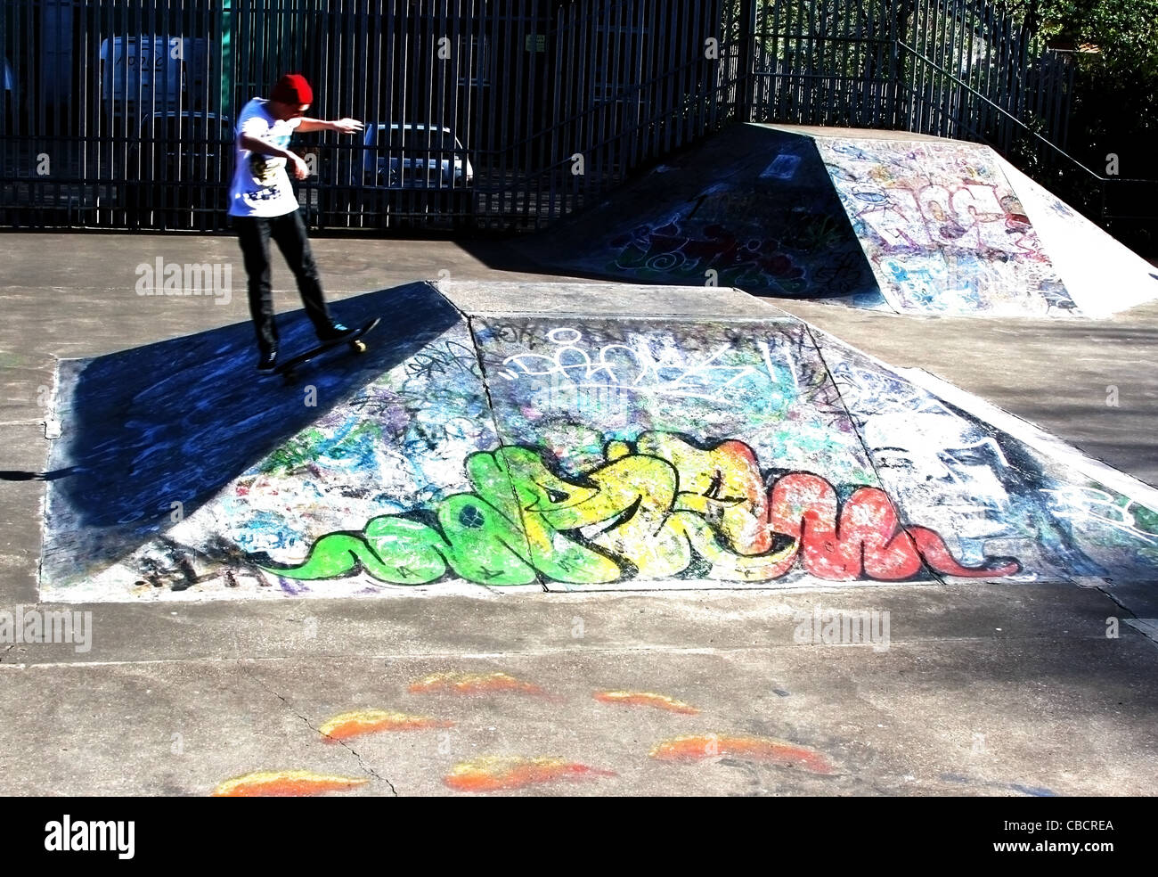 Skater skating on skayeboards jumping on colourfull graffiti Stock Photo