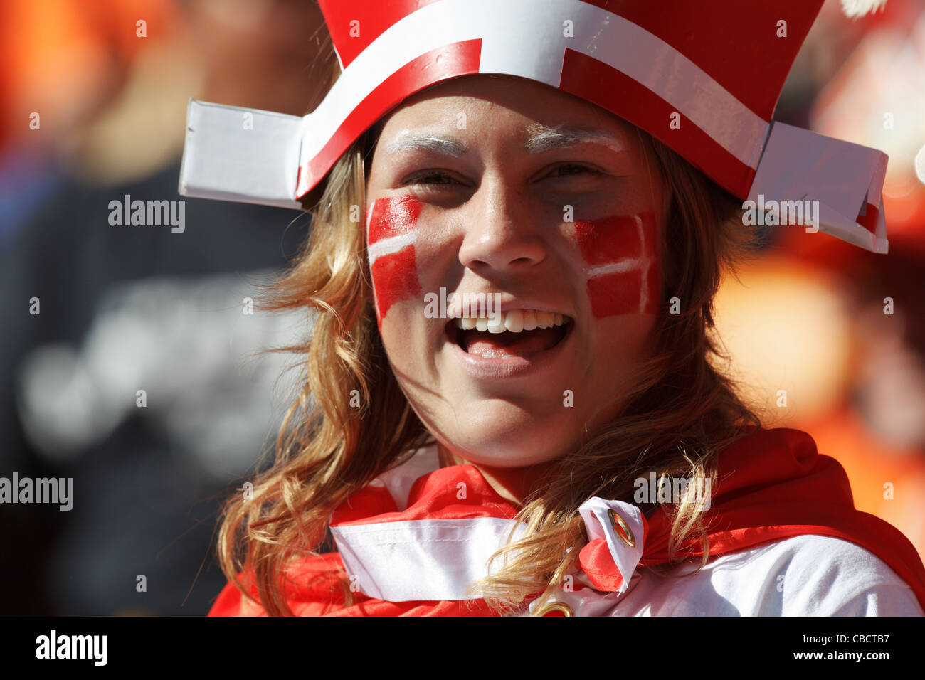 A Denmark supporter in the stands smiles at the 2010 FIFA World Cup soccer match between Denmark and the Netherlands. Stock Photo