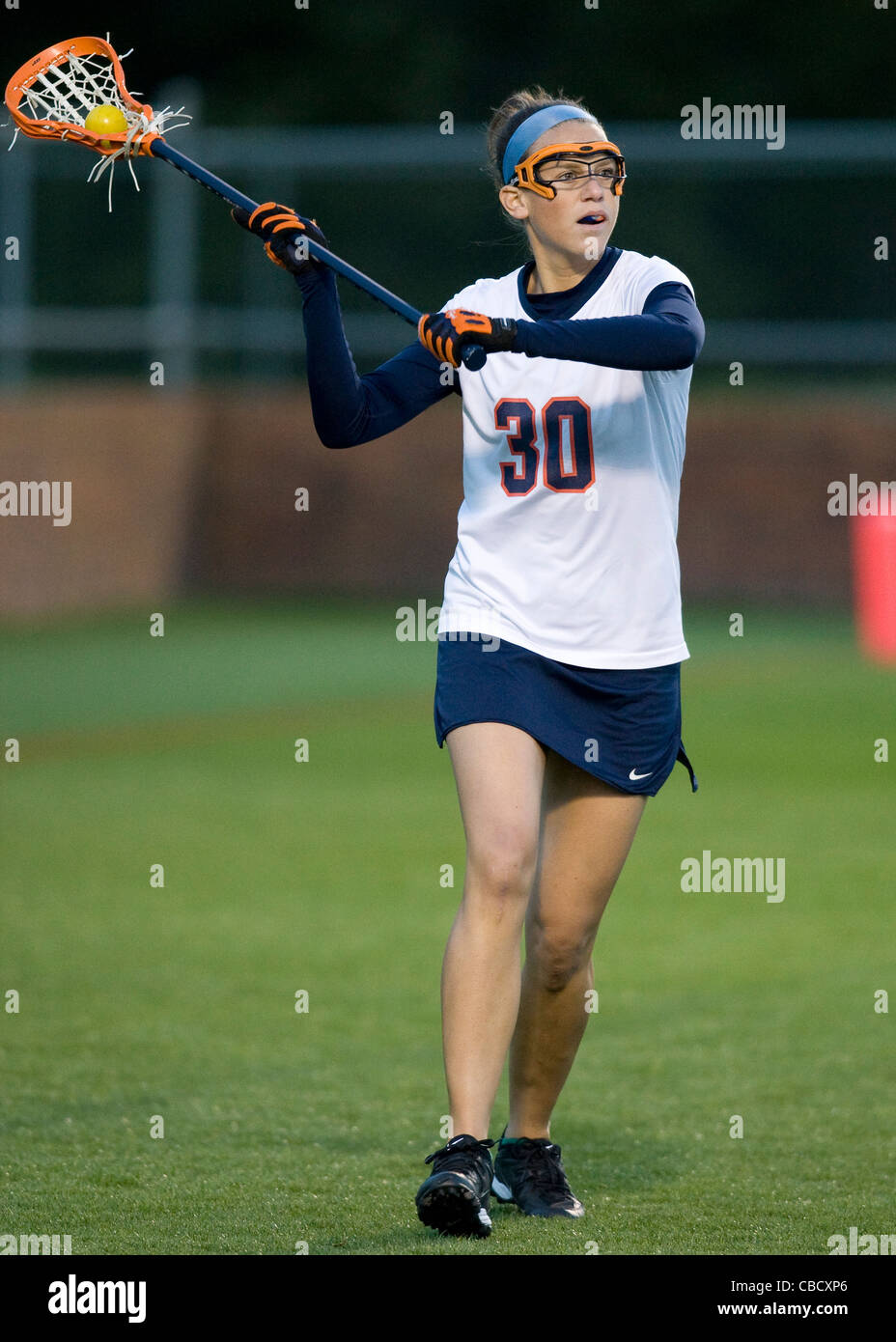 A female college lacrosse player in action during a game Stock Photo