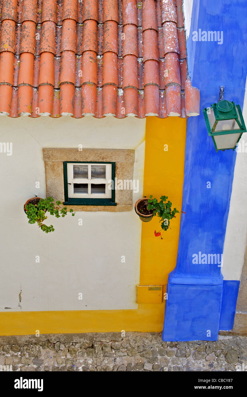 Window, Street Lamp and a Clay Tile Roof with a Pastel Colorful Wall in the Medieval Village of Obidos Stock Photo
