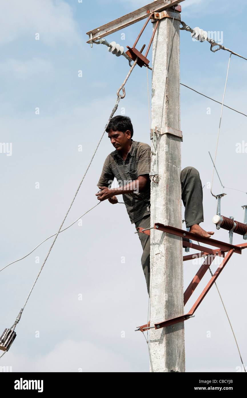 Indian Electrician working up an Electricity pylon replacing cables