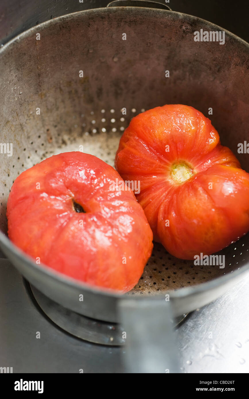 Peeled tomatoes in colander Stock Photo