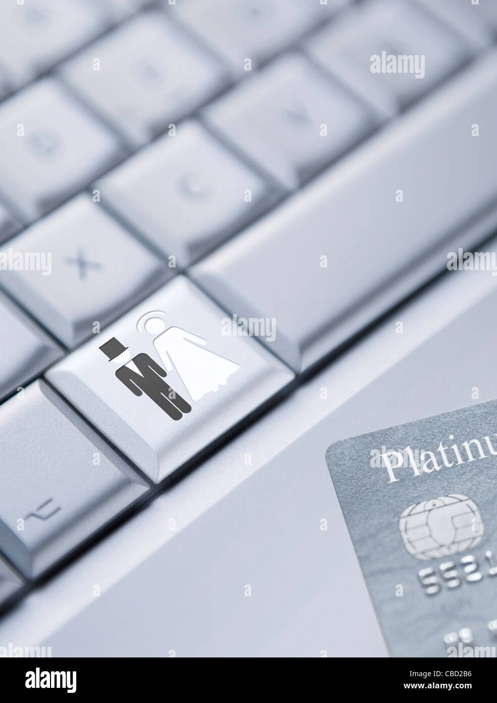 Detail of a laptop keyboard with a bride and groom symbol on one key and a credit card at the bottom right corner Stock Photo