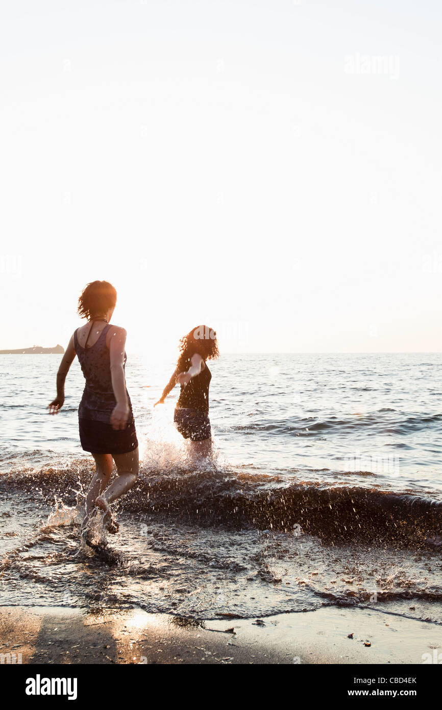 Women playing in waves on beach Stock Photo Alamy