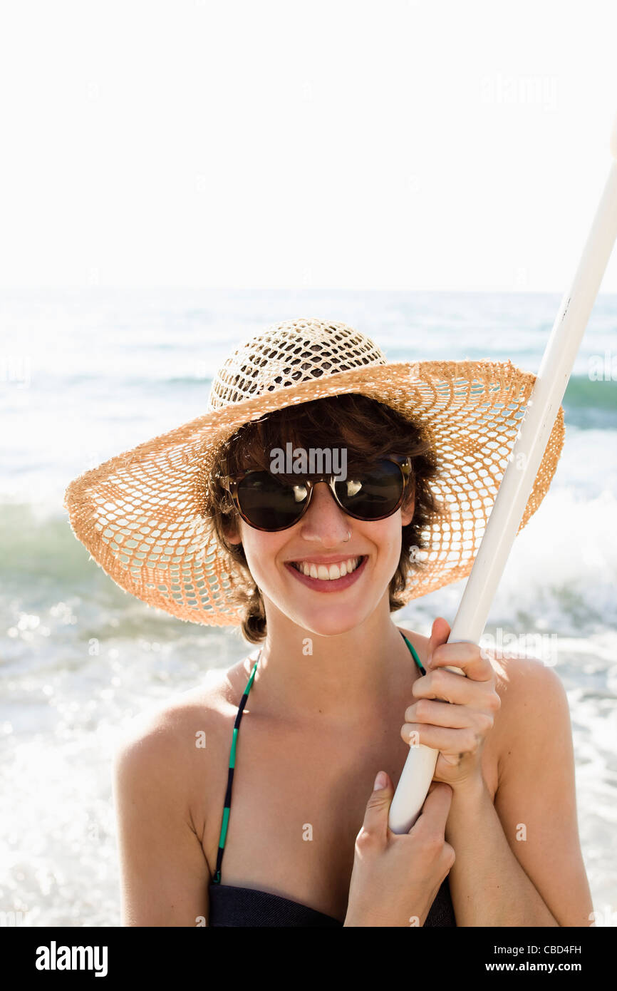 Woman holding pole on beach Stock Photo