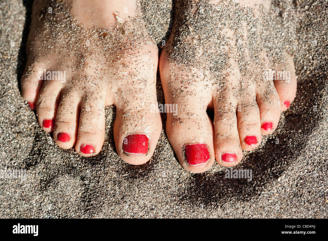 Close up of woman’s feet in sand Stock Photo