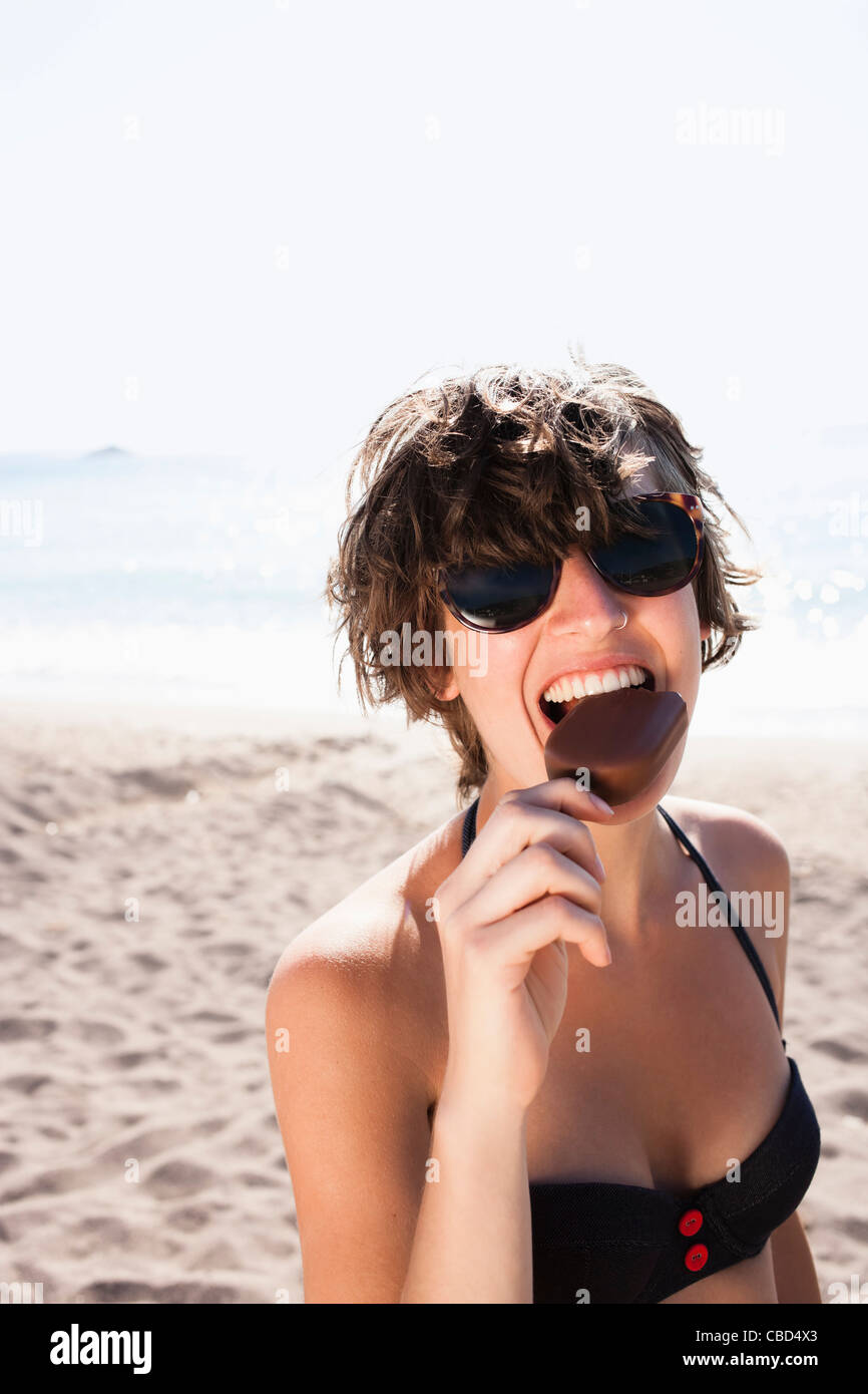 Woman eating ice cream on beach Stock Photo