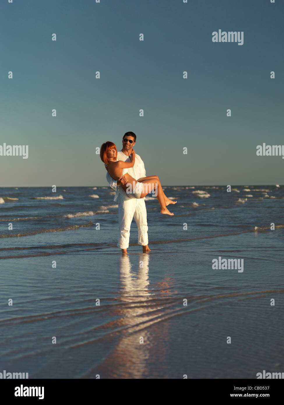 happy, young couple playing by the sea shore Stock Photo