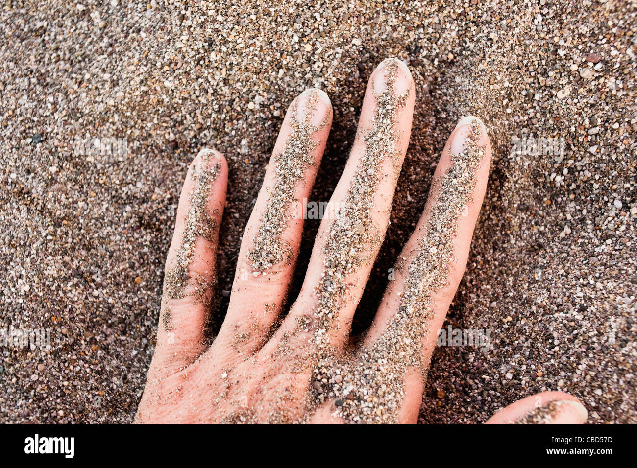 Close up of woman’s hand in sand Stock Photo