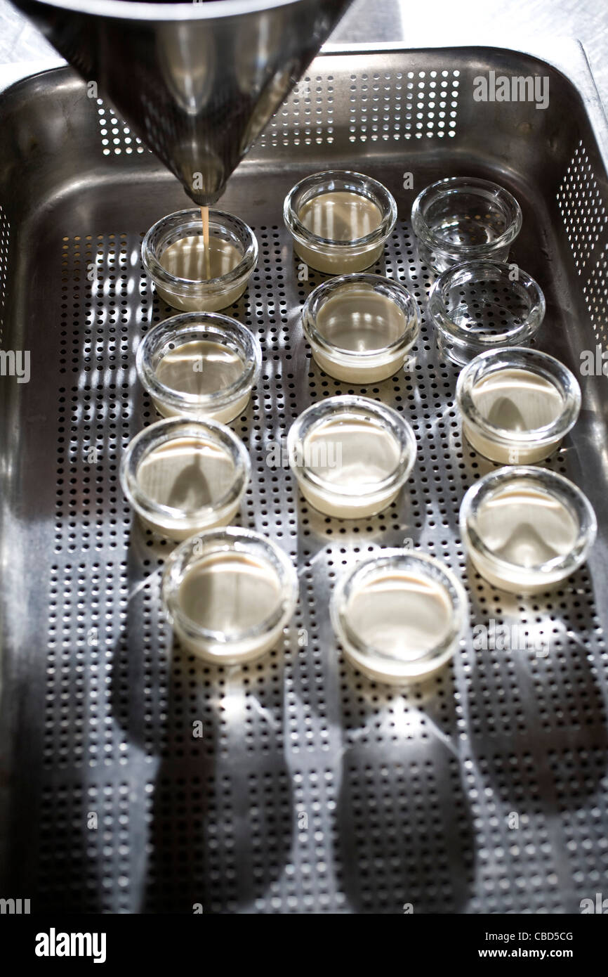 Spraying Ramekins Dispensing batter into glass ramekins, cropped Stock Photo - Alamy