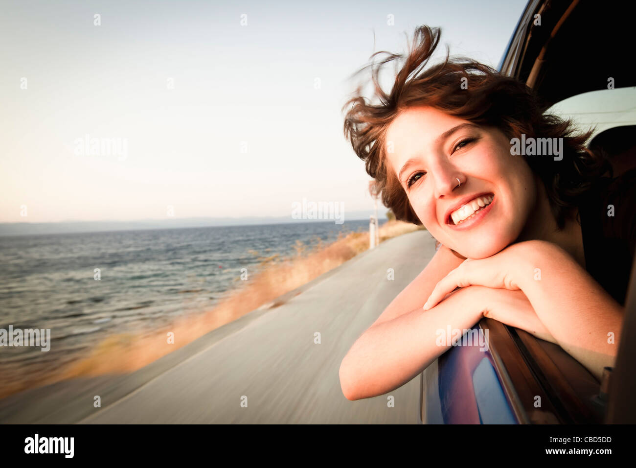 Woman smiling out of car window Stock Photo