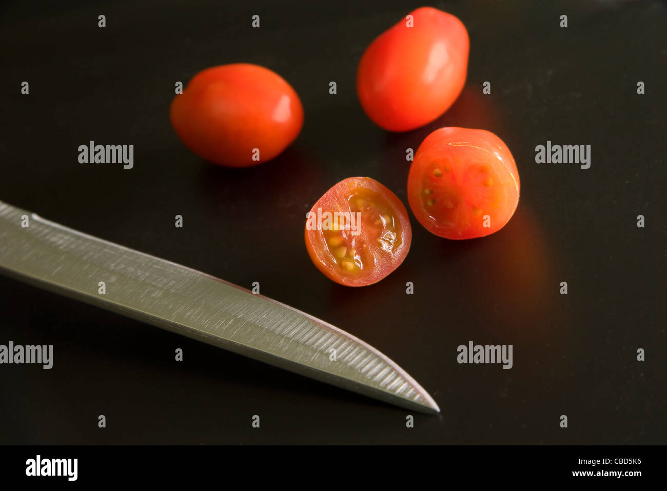 Cherry tomatoes and knife Stock Photo - Alamy
