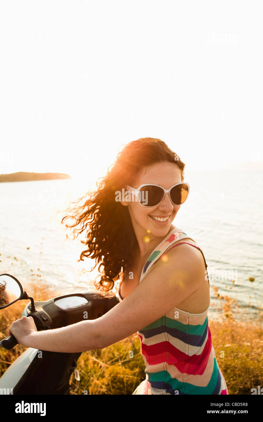Smiling women riding scooter Stock Photo