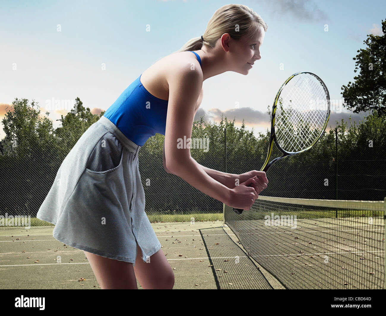Woman playing tennis on court Stock Photo