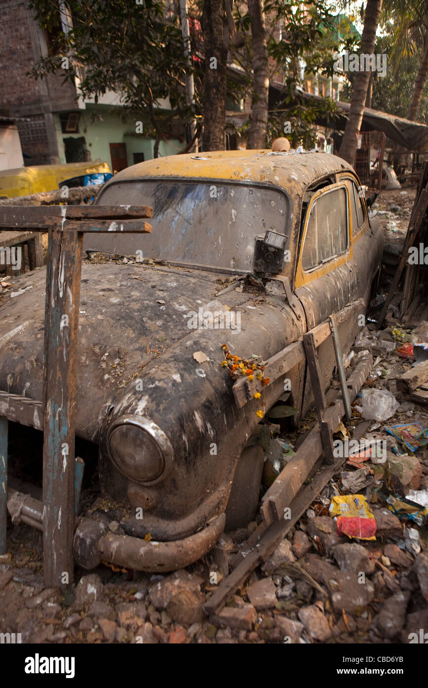 India, West Bengal, Kolkata, Rabindra Sarovar, derelict Hindustan Ambassador taxi buried in rubbish Stock Photo