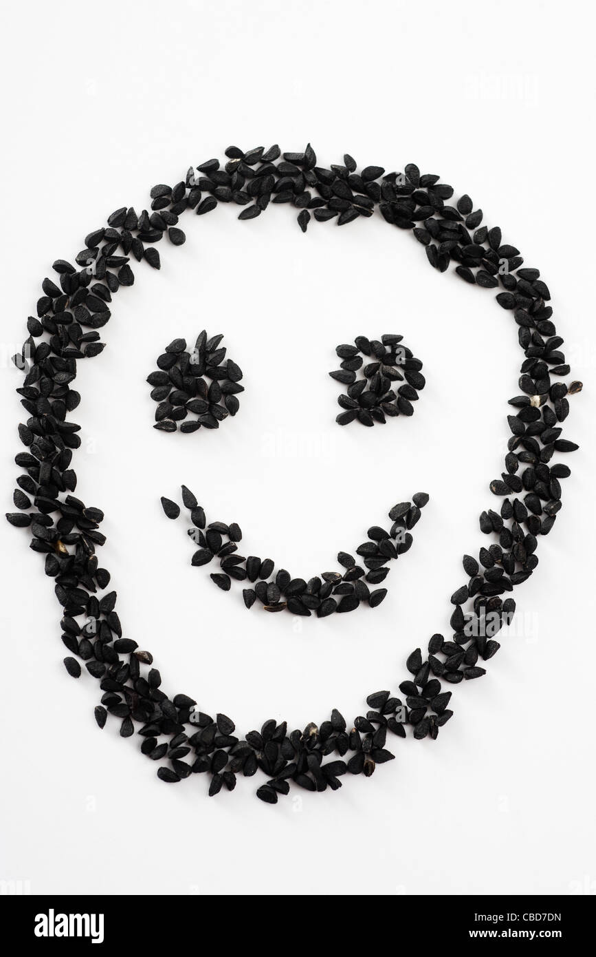 Nigella seeds arranged in smiley face Stock Photo