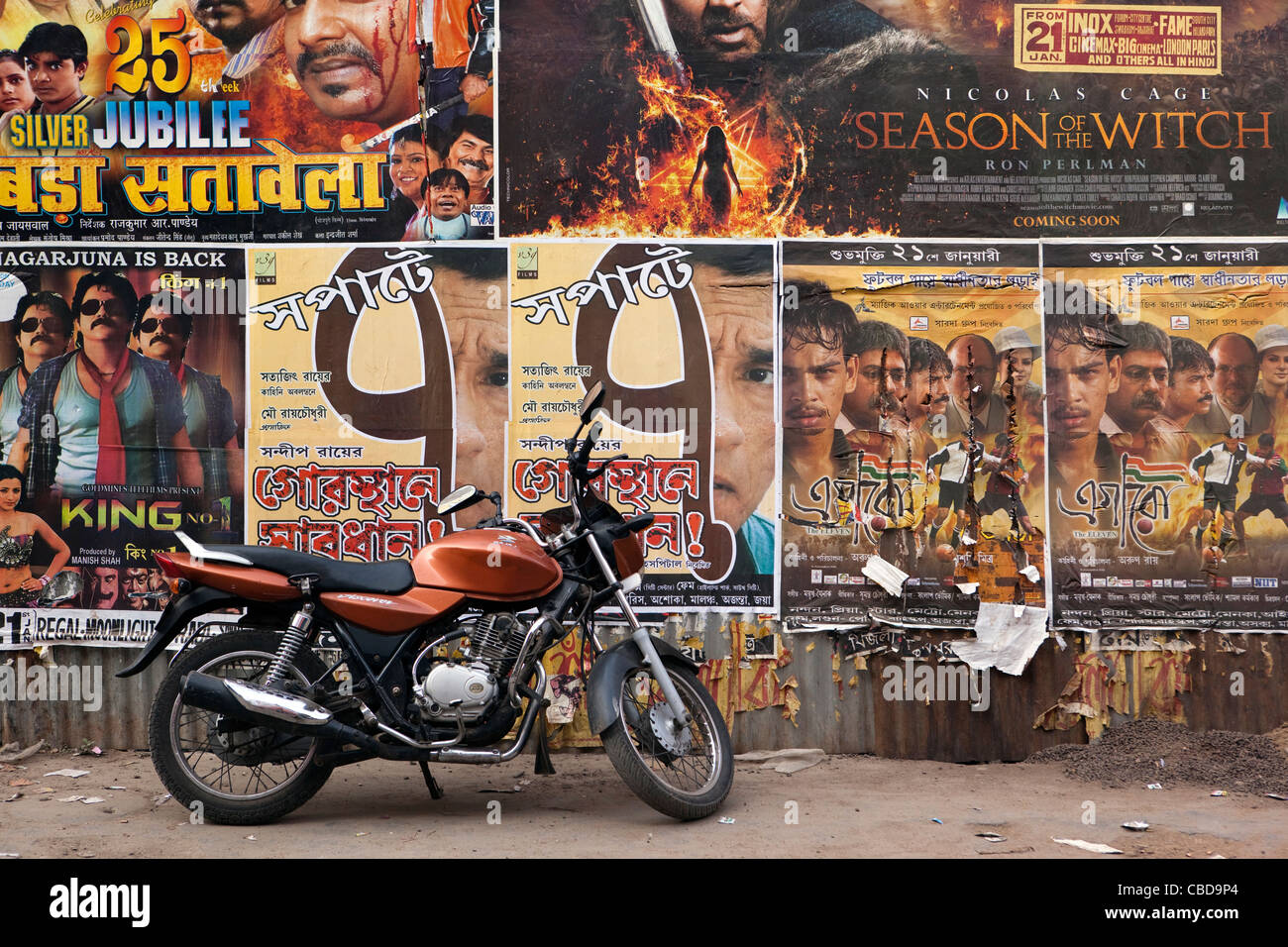 India, West Bengal, Kolkata, Rabindra Sarovar, motorcycle parked under cinema posters Stock Photo