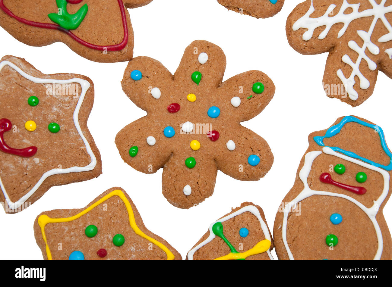 Snowflake gingerbread cookie in the middle of other colorful gingerbread cookies on white background Stock Photo