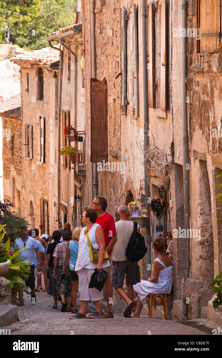 tourists looking around the back streets of St Guilhem le Desert Hérault Languedoc-Roussillon France Stock Photo