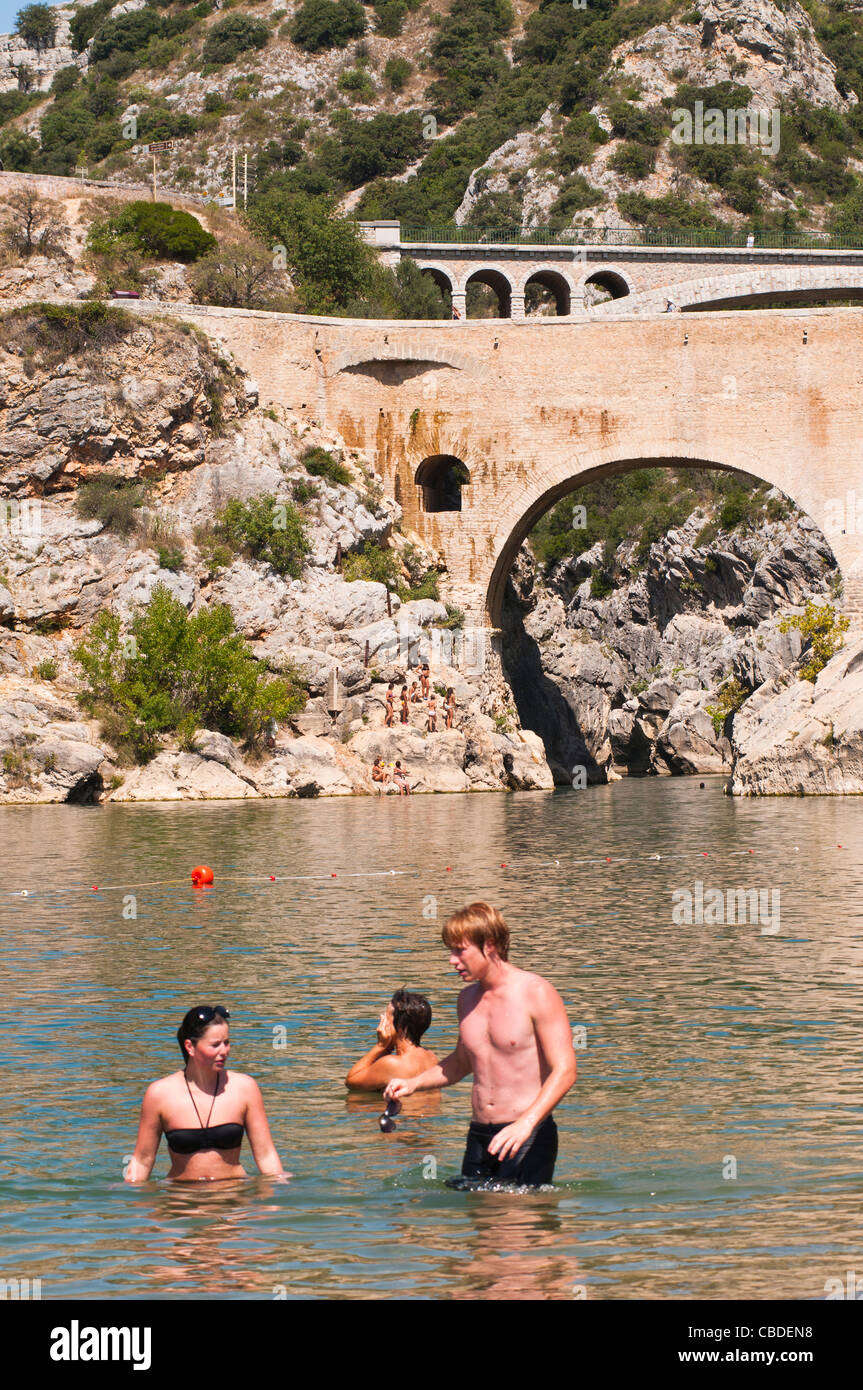 People swiming in the River Herault, Pont du Diable in the background, Languedoc Roussillon, France Stock Photo
