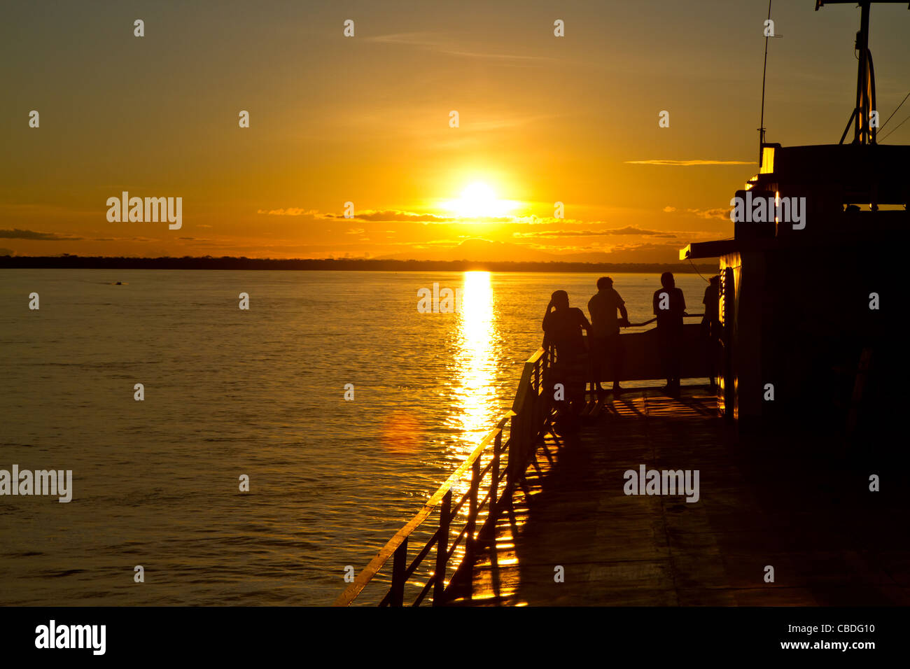 Some friends enjoy the last light on the Amazon river. Stock Photo