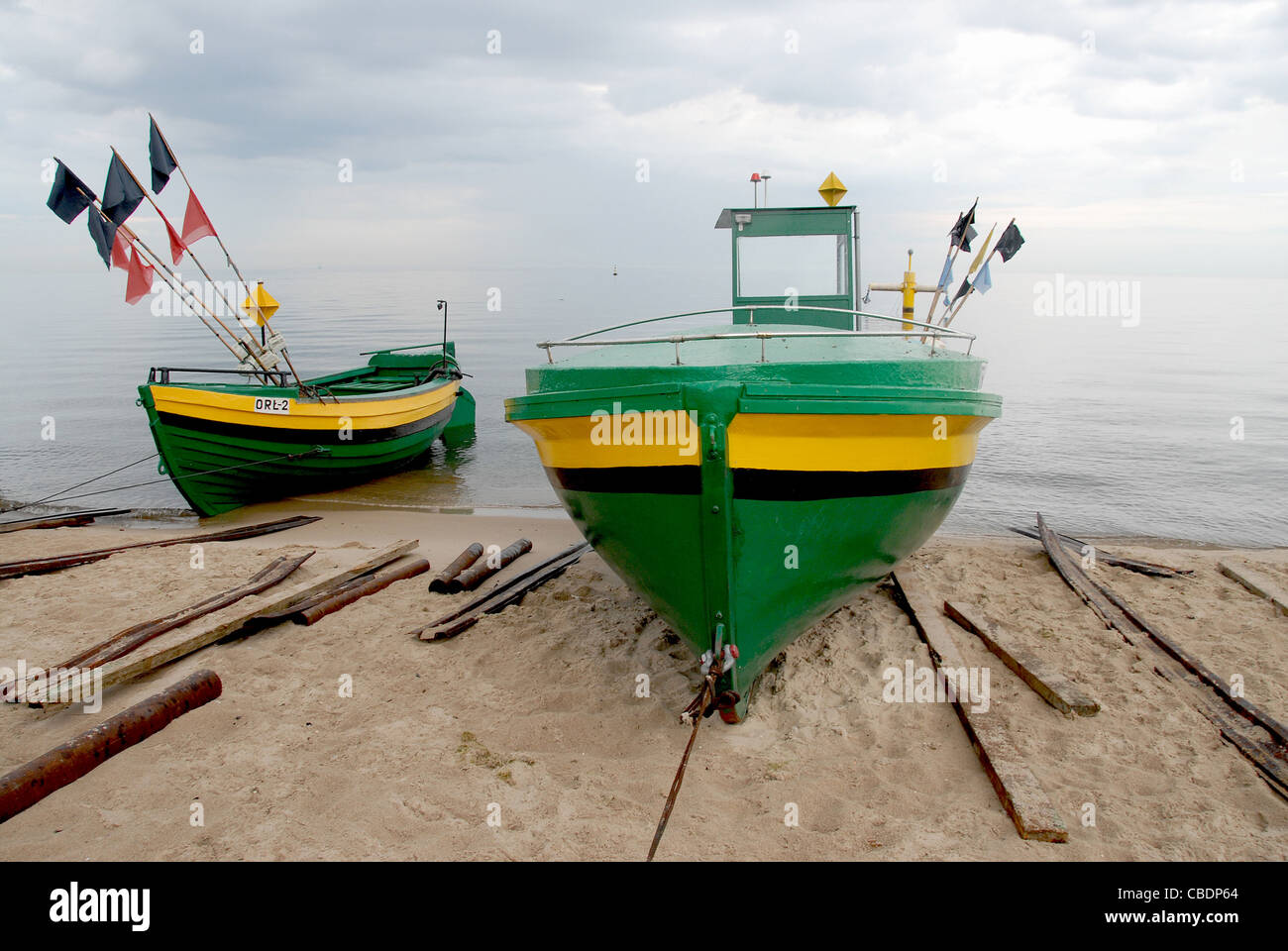 Yellow and green fishing boats on the shore of Orlowo, a district of Gdingen, Gdynia, on the Baltic Sea of Pomerania, Poland Stock Photo