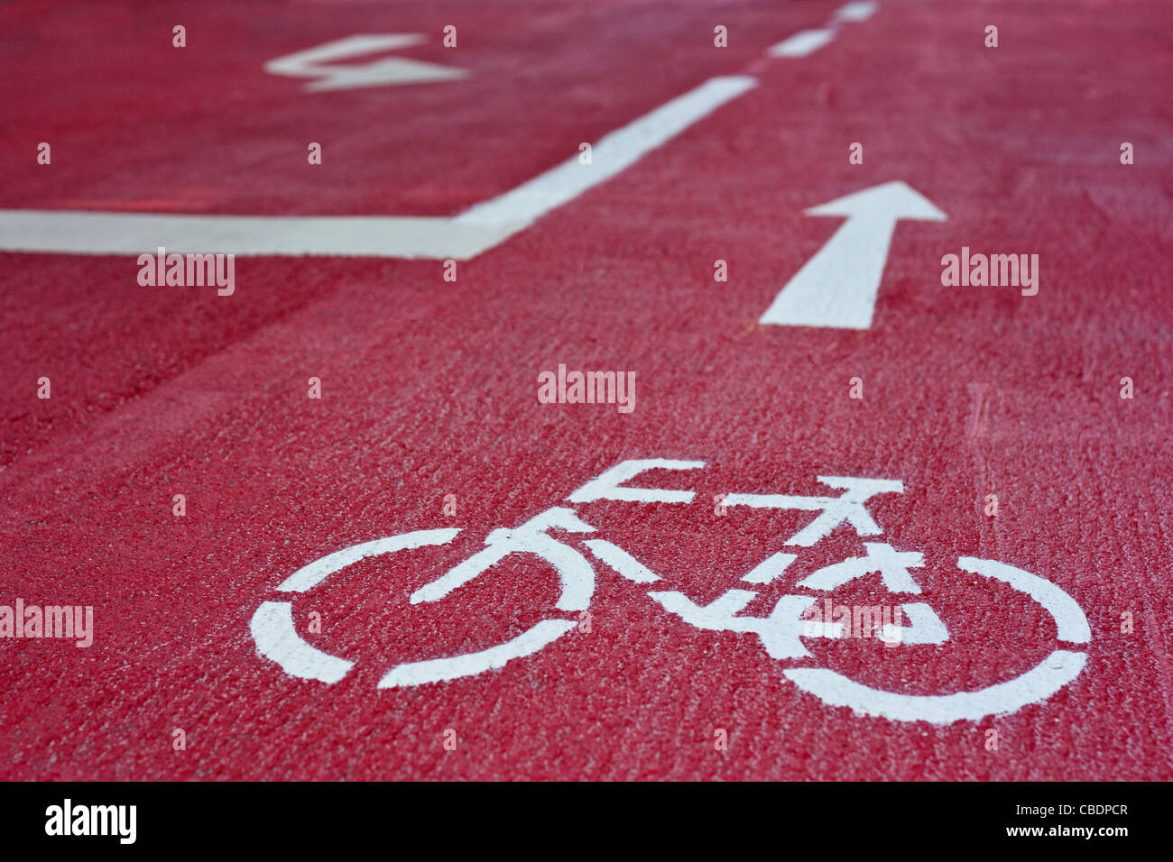 Red bicycle route with white sign and arrows in the city of Graz, Styria, Austria Stock Photo