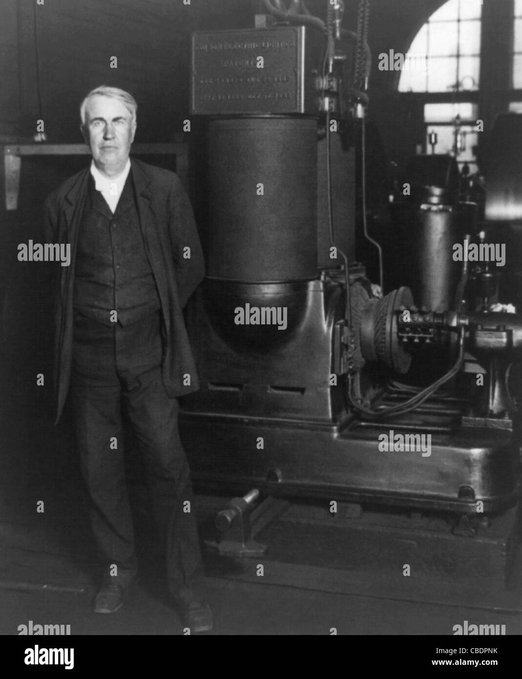 Vintage photo of American inventor and businessman Thomas Alva Edison (1847 – 1931). Edison is pictured circa 1906 with his original dynamo at the Edison Works in Orange, New Jersey. Stock Photo