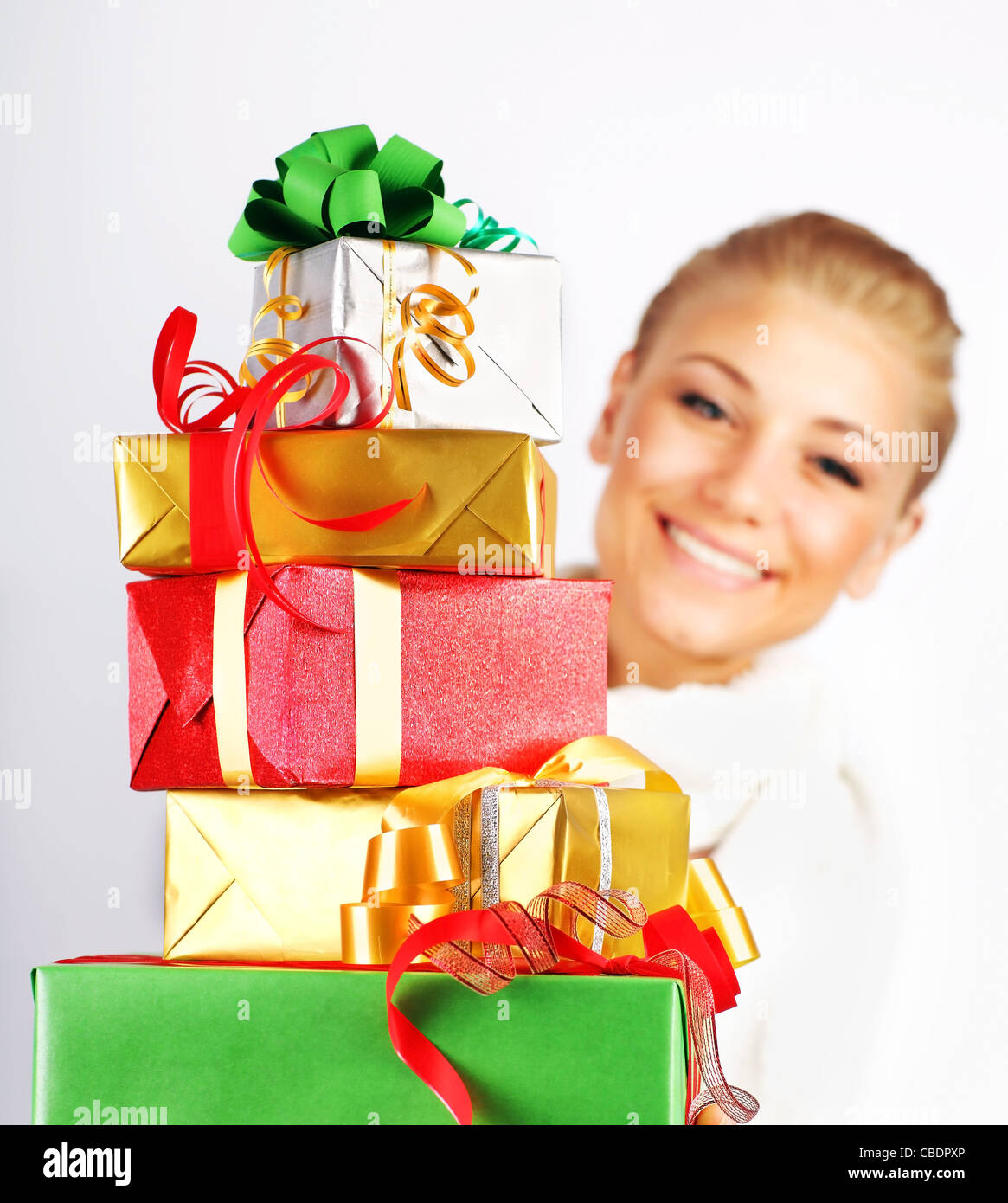 Happy girl smiling, holding colorful holiday presents & gift boxes as Christmas & new year ornament decoration isolated on white Stock Photo