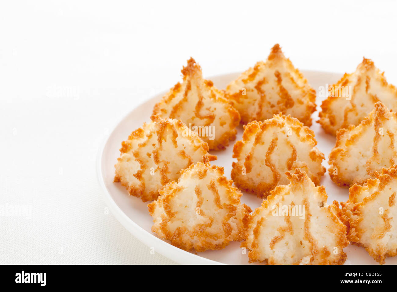 coconut macaroon cookies on white plate against tablecloth Stock Photo