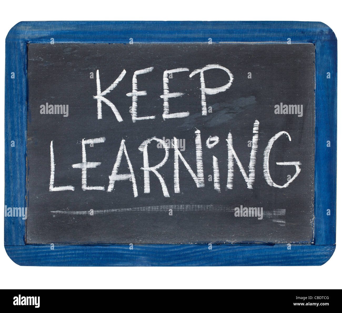 Keep learning white chalk on a small slate blackboard isolated on white Stock Photo