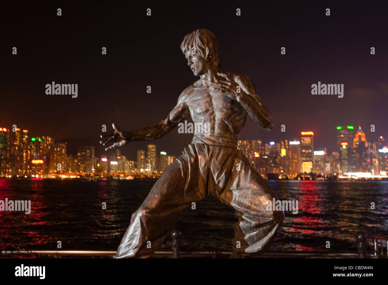 Kung Fu film star Bruce Lee statue against Hong Kong Island skyline. On the Avenue of Stars promenade, Kowloon. China Stock Photo