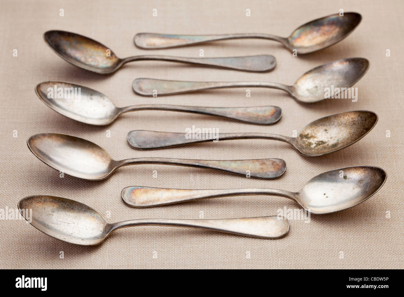 old grunge silver spoons with scratches and patina on tablecloth, shallow depth of field Stock Photo