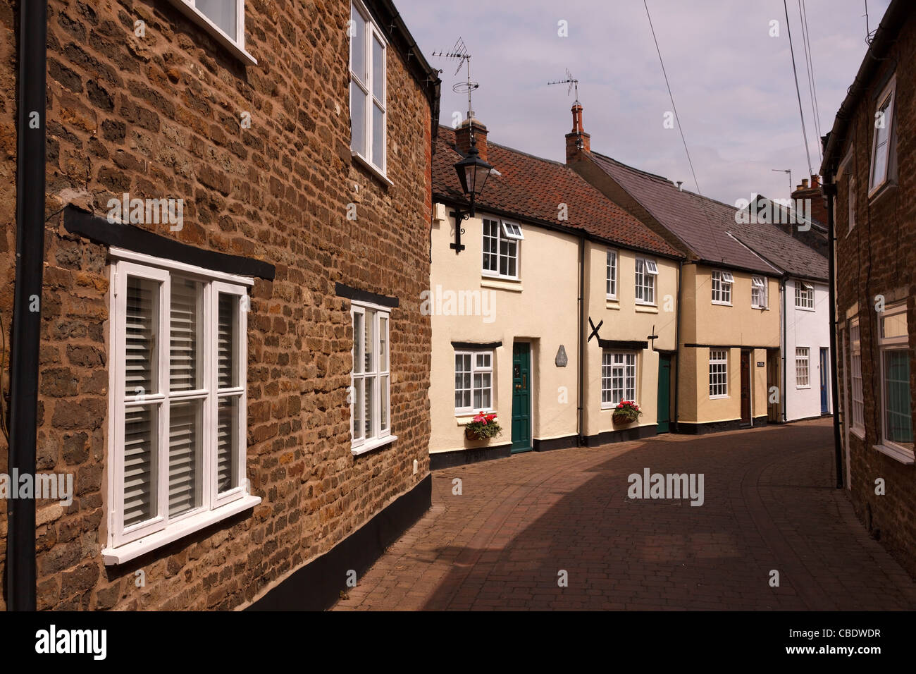 Terraced row of beautiful old painted English cottages in narrow back street, Dean's Street, Oakham, Rutland, England, UK Stock Photo