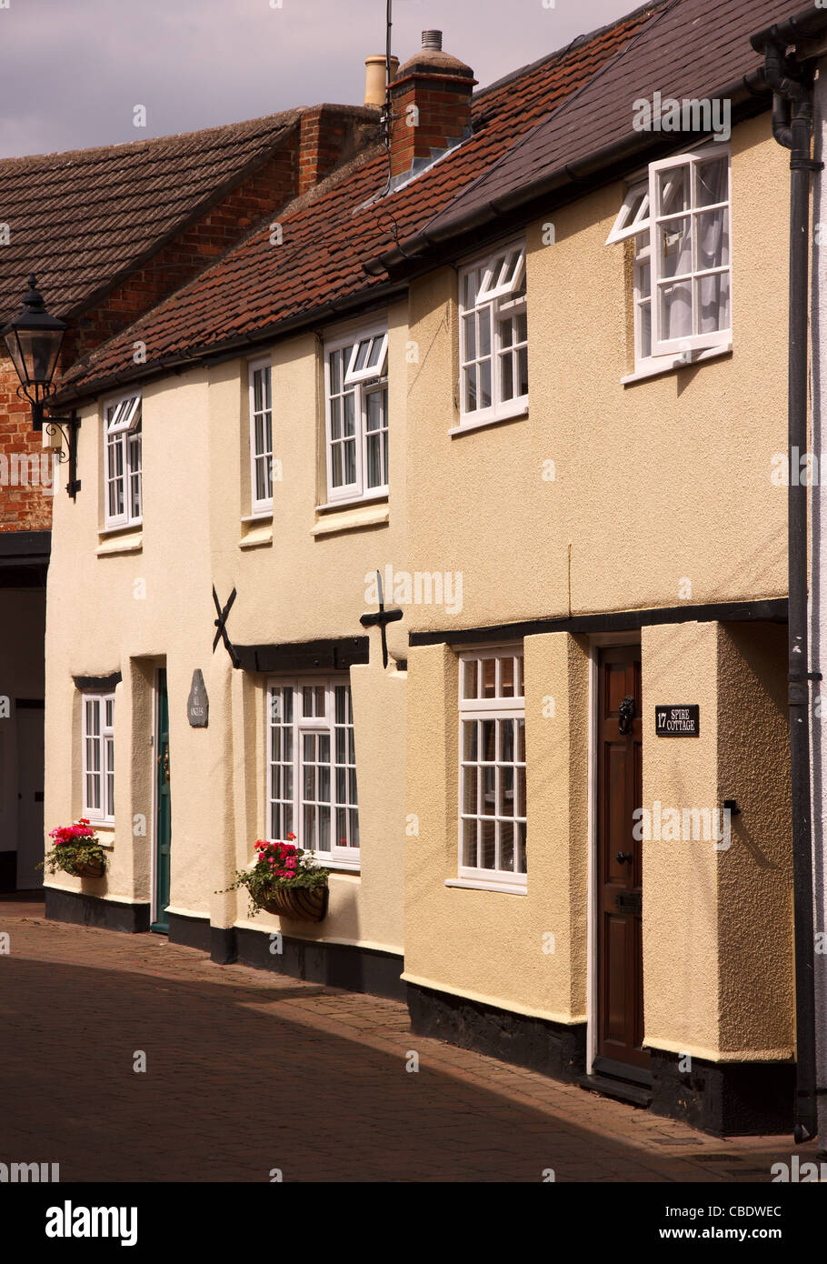 Terraced row of beautiful old painted English cottages in narrow back street, Dean's Street, Oakham, Rutland, England, UK Stock Photo