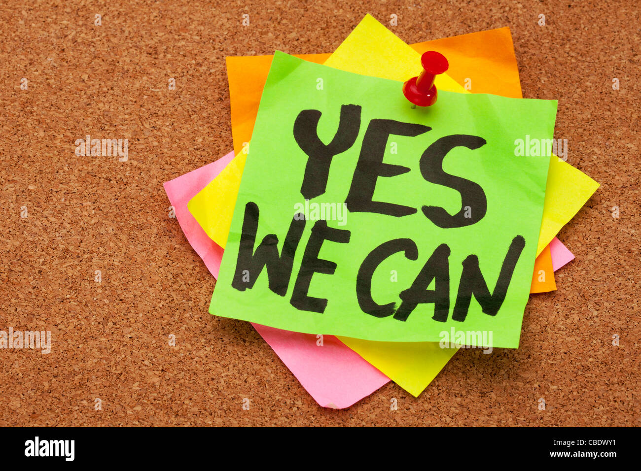 yes we can - motivational slogan on a stack of sticky notes posted on cork bulletin board Stock Photo