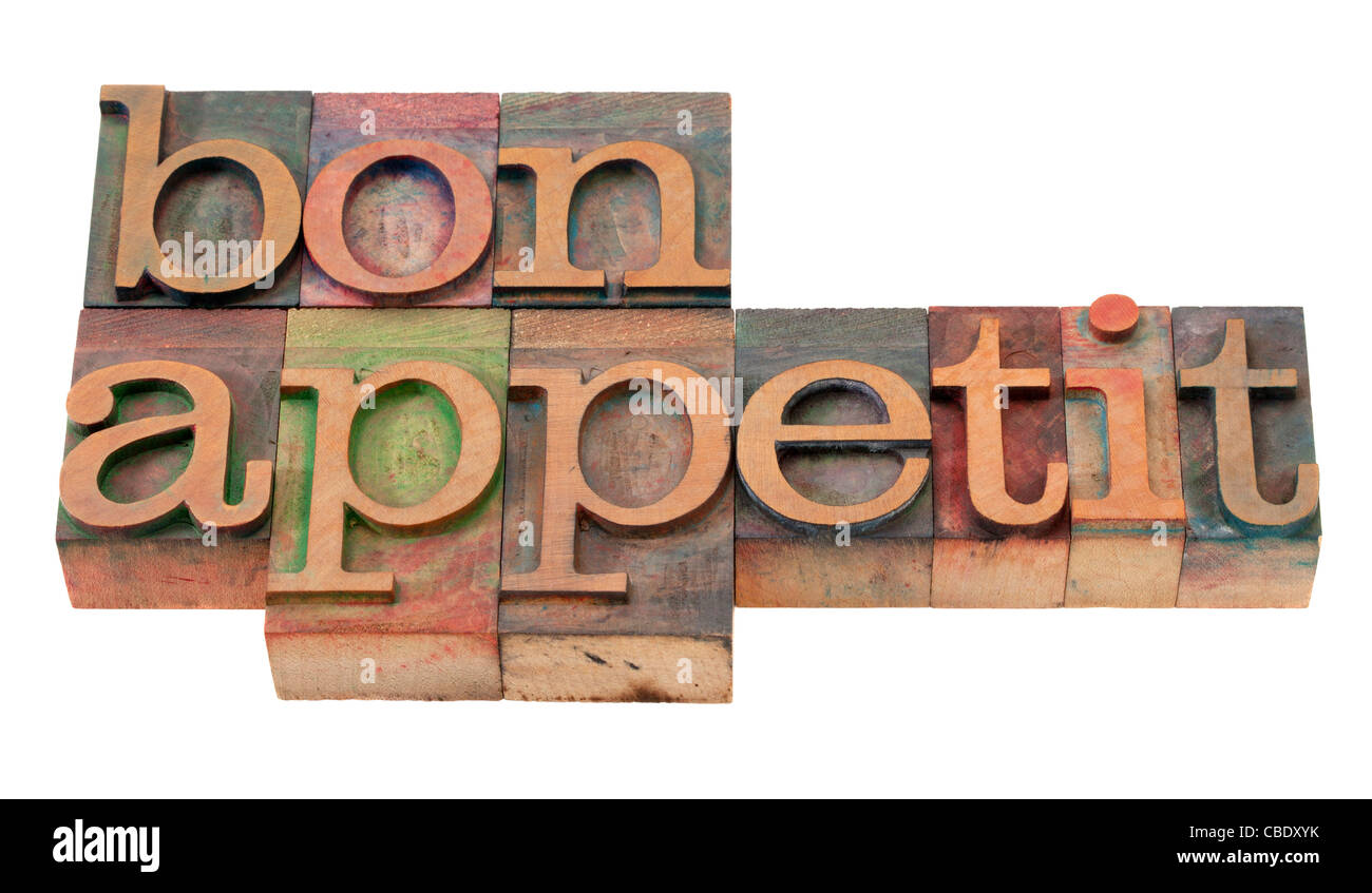 bon appetit - phrase in vintage wooden letterpress printing blocks, stained by color inks, isolated on white Stock Photo