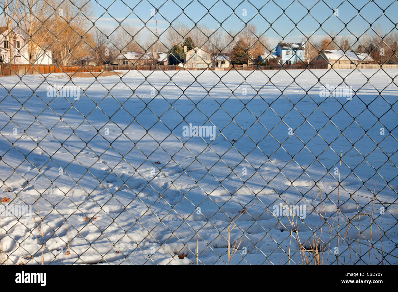 view through chain link fence on a typical residential neighborhood in Fort Collins, Colorado; winter scenery Stock Photo