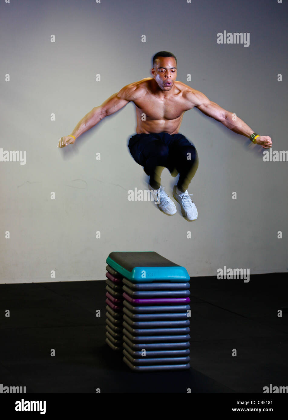Black man doing box jumps in gym Stock Photo Alamy