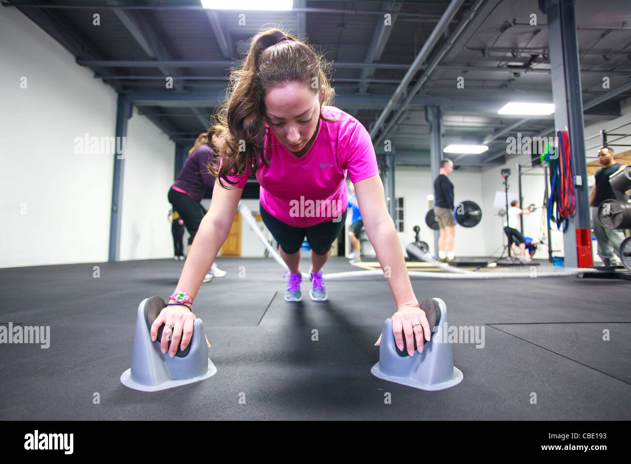 Young woman doing planks and pushups in gym weightroom Stock Photo - Alamy
