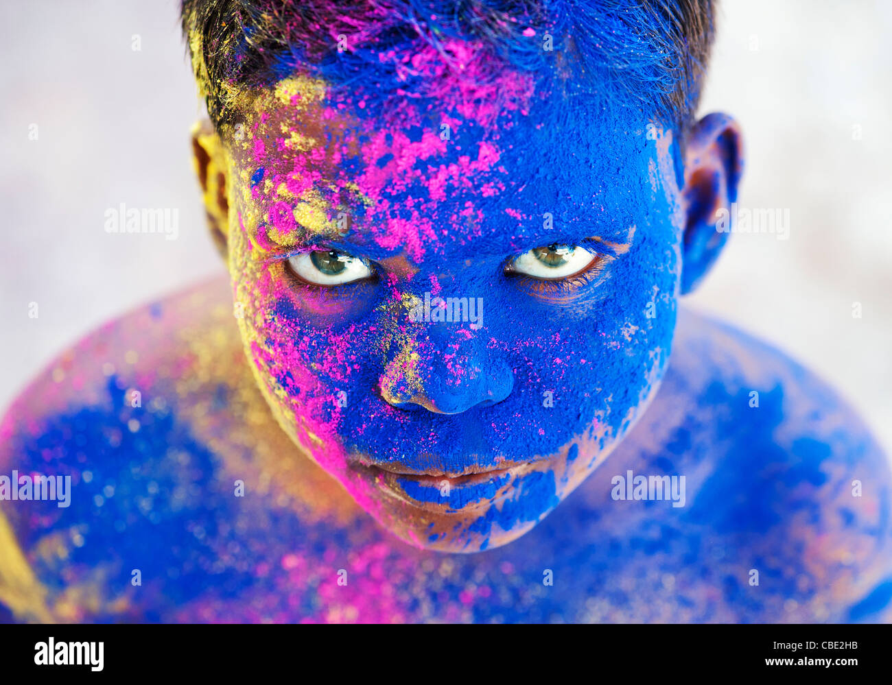 Young Indian boy covered in coloured powder pigment Stock Photo
