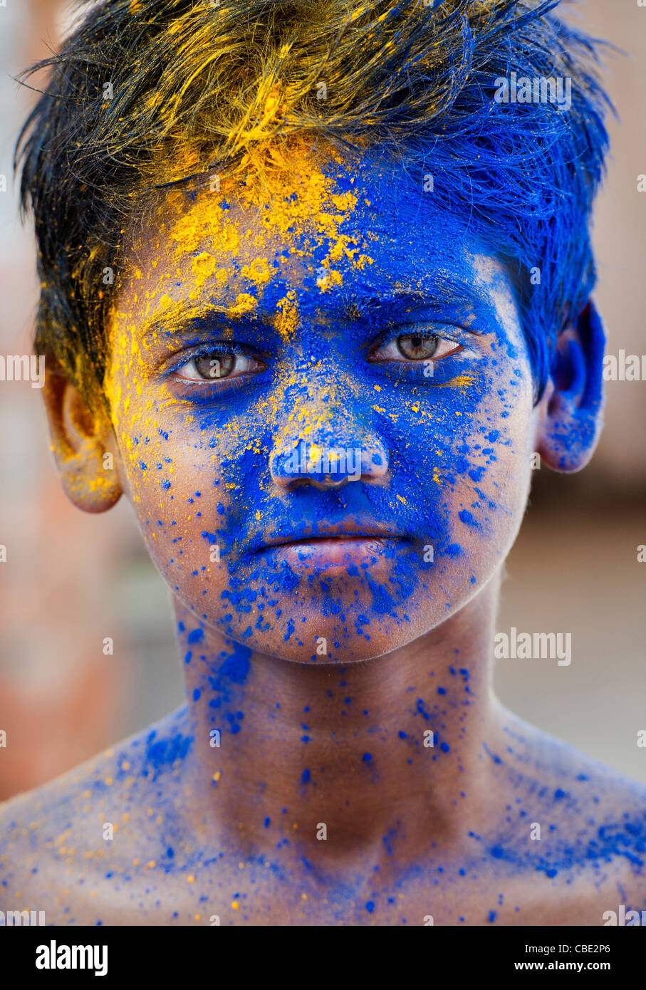 Young Indian boy covered in coloured powder pigment Stock Photo