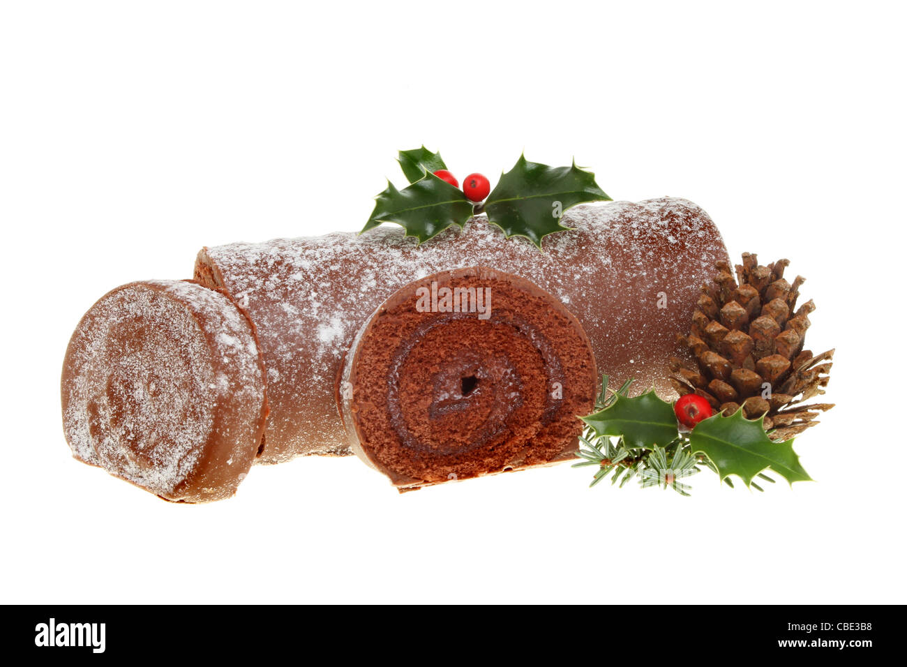 Christmas chocolate log decorated with holly pinecone and leaves isolated on white Stock Photo