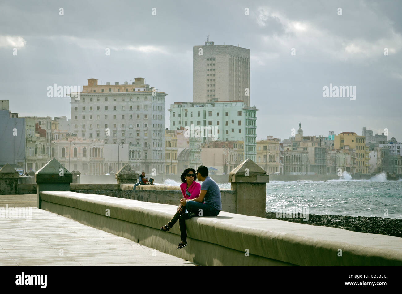 Young couple sitting on the wall of El Malecon Havana Cuba Stock Photo