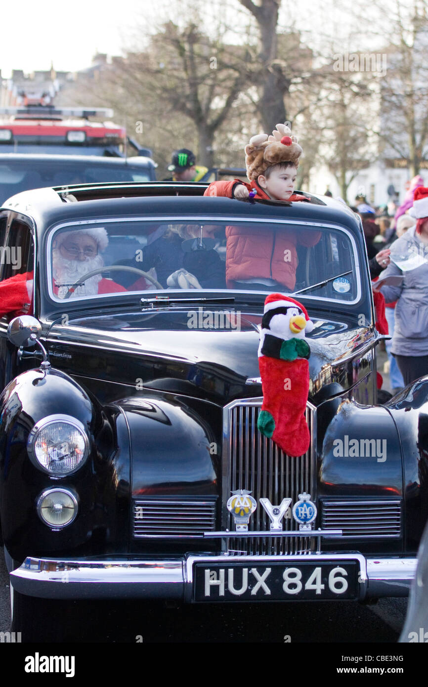 Father Christmas Driving his car with Rudolf the red nosed reindeer at the Buckingham Christmas Parade England Stock Photo