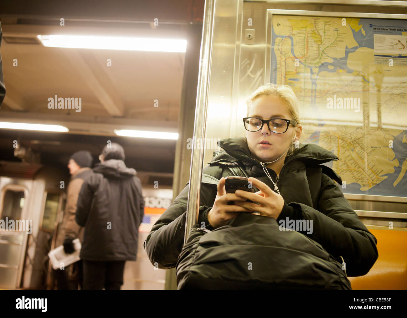 A woman listens to music near an open door on the subway in New York Stock Photo Alamy