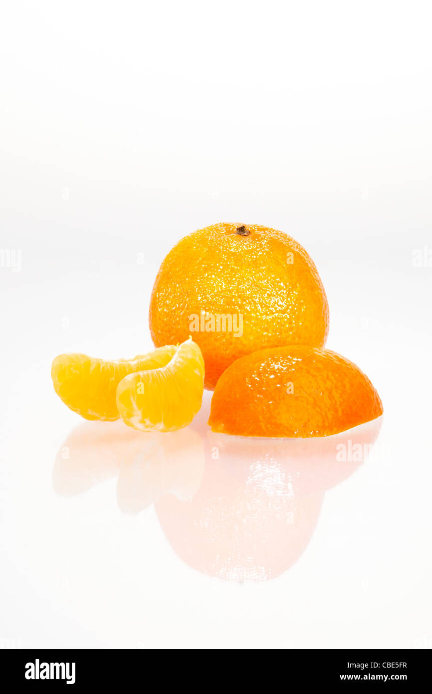 Sliced ​​mandarins with reflection in front of white background Stock Photo