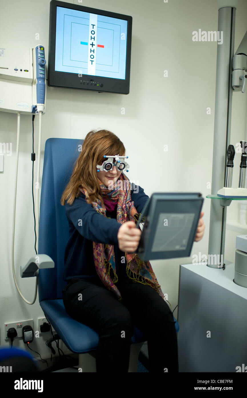 A 13 year old teenage girl having her eyes tested at an National Health Service NHS opticians, UK Stock Photo